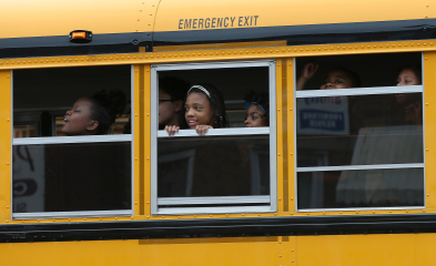 BALTIMORE, MD - MAY 01: Children riding home from school on a school bus watch as Baltimore residents celebrate at the corner of West North Avenue and Pennsylvania Avenue after Baltimore authorities released a report on the death of Freddie Gray on May 1, 2015 in Baltimore, Maryland. Marilyn Mosby, Baltimore City State's Attorney, ruled the death of Freddie Gray a homicide and that criminal charges will be filed. Gray, 25, was arrested for possessing a switch blade knife on April 12 outside the Gilmor Houses housing project on Baltimore's west side. According to his attorney, Gray died a week later in the hospital from a severe spinal cord injury he received while in police custody. (Photo by Win McNamee/Getty Images)